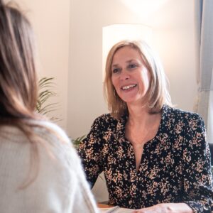 Fabienne Verron, Thérapeute souriante en consultation, échange bienveillant dans un espace chaleureux et apaisant.