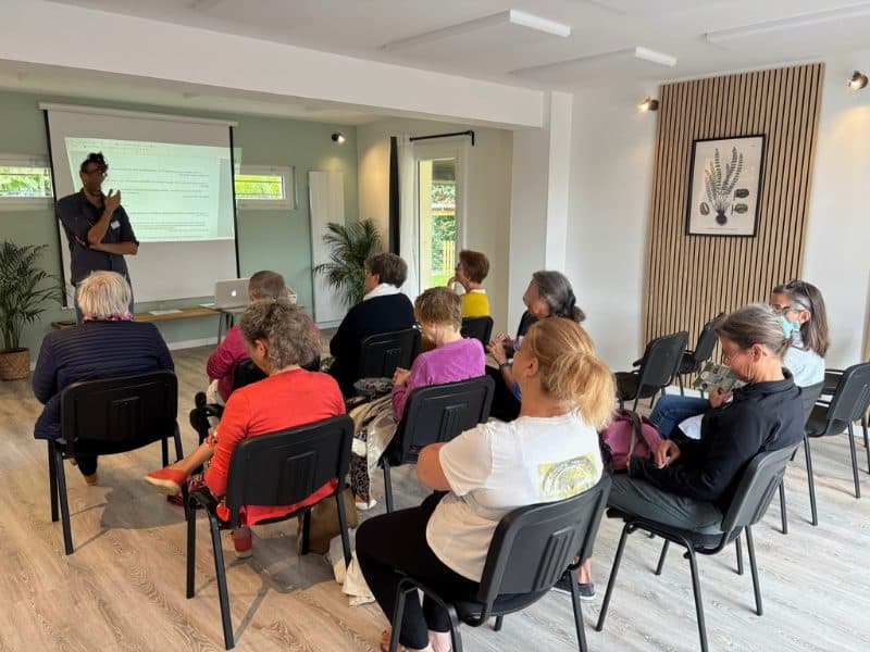 Salle Hestia configurée en mode théâtre pour une conférence d'entreprise : rangées de chaises face au conférencier dans un espace lumineux dédié aux séminaires à l'Espace Tulsi.