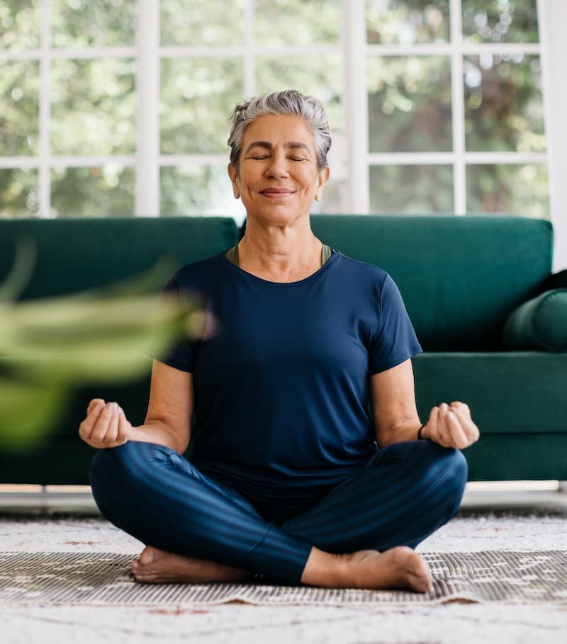 Femme méditant paisiblement dans un espace lumineux et naturel, favorisant le bien-être et la détente.